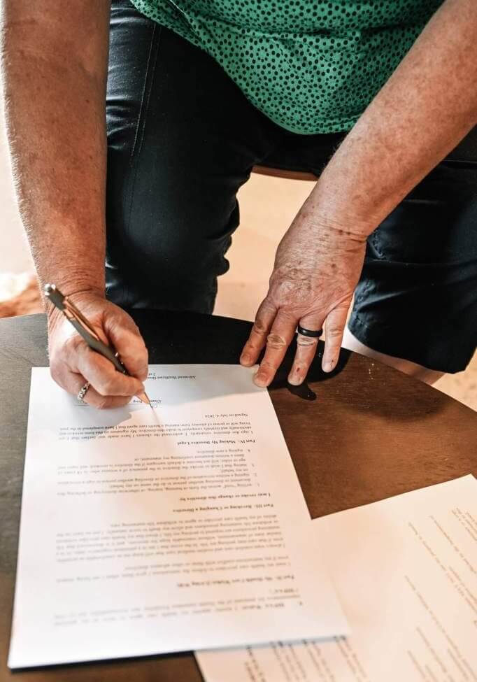 Client signing paperwork after meeting with Marne